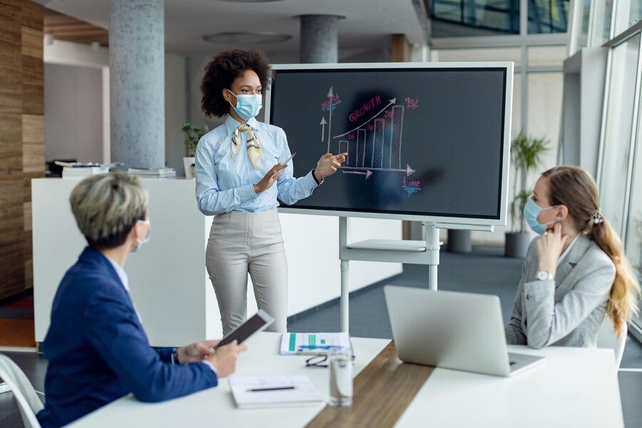 black-businesswoman-with-protective-face-mask-giving-presentation-office_637285-9859